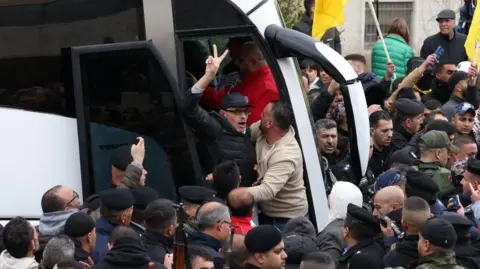 EPA-EFE/REX/Shutterstock A released Palestinian prisoner shows a victory sign after arriving in the West Bank city of Ramallah. Photo: 8 February 2025