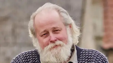 LDRS Arnold Warkenen, a North Yorkshire Green Party councillor and retired organic farmer with a white beard and hair, wearing a navy and white jumper