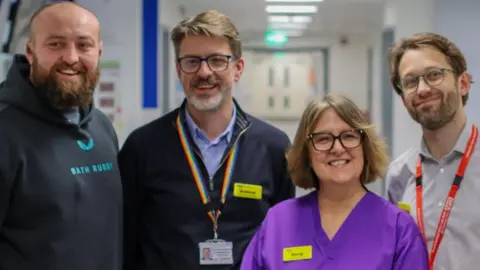 NHS Bath Rugby player Tom Dunn pictured alongside staff at the opening of the new unit.