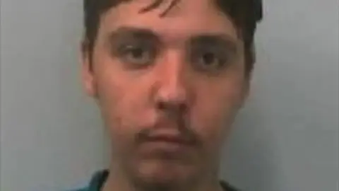 Avon and Somerset Police A mugshot of Jason Conroy. He has brown hair and is looking directly at the camera