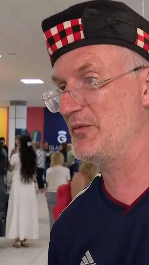 Man wearing glasses and Scotland hat at Glasgow Airport