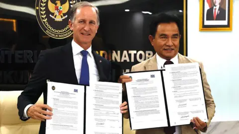 The Netherlands' Ambassador to Indonesia Marc Gerritsen and Indonesia's Coordinating Minister for Law, Human Rights, Immigration, and Correctional Institutions, Yusril Ihza Mahendra, pose with documents