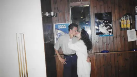 Norman Taylor A photo of a couple kissing in a bar.