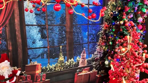 Some Christmas decorations seen inside the house, in a heavily-decorated window.