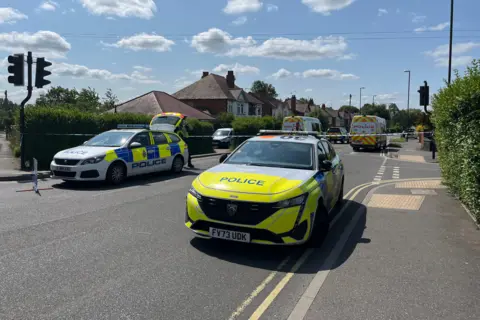 Police vehicles and officers in Stenson Road, Derby, on the morning of 16 June 2025