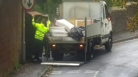 Wolverhampton City Council A council worker removes fly-tipped rubbish from a pavement