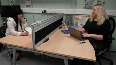Paula Edwards and Nicole Dodds from the charity Salute Her UK sit around a desk at the charity's headquarters in Dudley in Northumberland. 