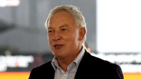 Then Auckland mayor Phil Goff, in a checkered shirt and black coat