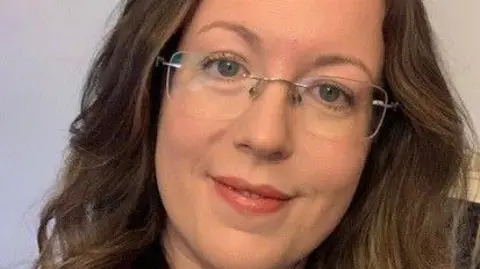 Emma King Emma smiles into the camera. She has brown hair and is wearing glasses. 