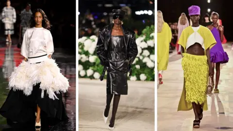 Getty Images Three models wearing a white top and black skirt with white feathers around the hips; a black leather dress and jacket with sunglasses and a peaked cap plus white high heels; plus a yellow, feathered skirt and white and yellow top with a purple peaked cap