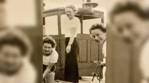 Exbury Veterans Association  A black and white picture shows three Wrens on Beaulieu River, near HMS Mastodon. The three white women are looking at the camera and smiling