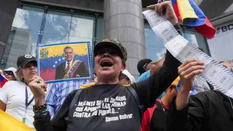 Reuters A demonstrator holds a picture of opposition candidate Edmundo Gonzalez during a demonstration to protest election results that awarded Venezuela's President Nicolas Maduro with a third term, in Caracas, Venezuela July 30, 2024