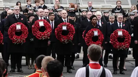 หัวหน้าพรรค PA Media UK Gavin Robinson, Stephen Flynn, Ed Davy, Kemi Badenoch และ Sir Kier Stammer ยืนเข้าแถวถือพวงหรีดดอกป๊อปปี้