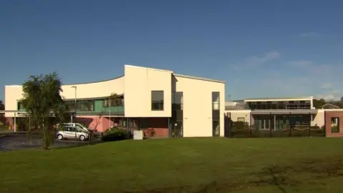 image sows the outside of grangewood, a mental health unit in Londonderry. A number of buildings can be seen, as can a number of cars parked utside them.