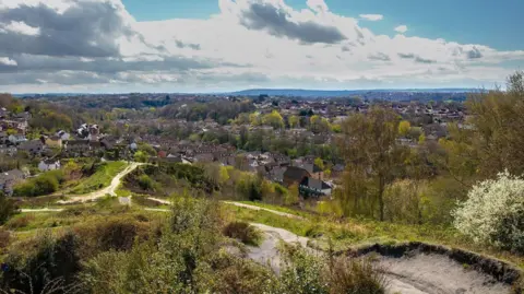 Getty Images A green hill with paved out paths overlooking homes in Bristol