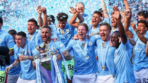 Manchester City players lift the Premier League trophy