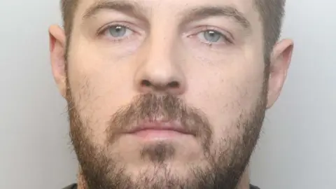 Cheshire Police A police photograph of Robin Vaughan, he looks at the camera with a neutral expression. He has short brown hair and a short brown beard