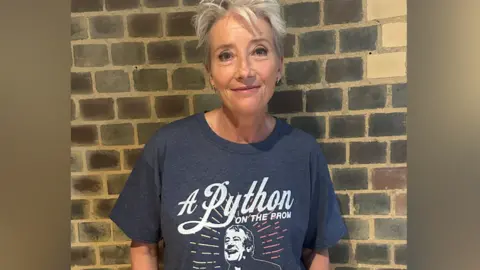 Actress Dame Emma Thompson in a dark grey T-shirt with a picture of Terry Jones and the slogan A Python on the prom