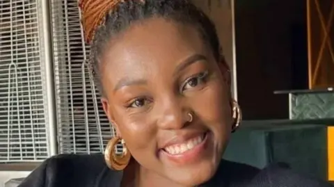 A close-up of Olorato Mongale smiling and wearing earrings 