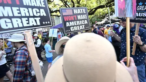 Getty Images Protestors hold signs that say "Hate Won't Make America Great" as they march in Houston
