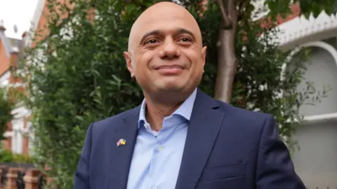 Reuters Sajid Javid pictured leaving his location  successful  London, July 6, 2022, seen with trees and houses successful  the background