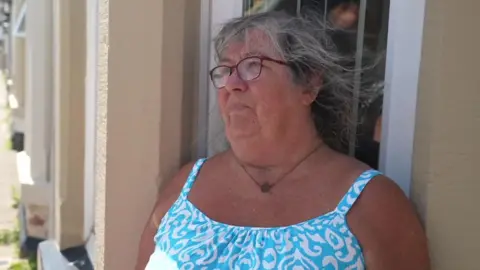 Janet Tensey a middle-aged woman stood outside a terraced house
