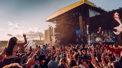 Matt Eachus Leeds festival 2024. Crowds gather in front of the main stage on a summer's evening. 