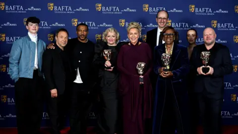 Getty Images The cast of Adolescence stand together with four Bafta awards.