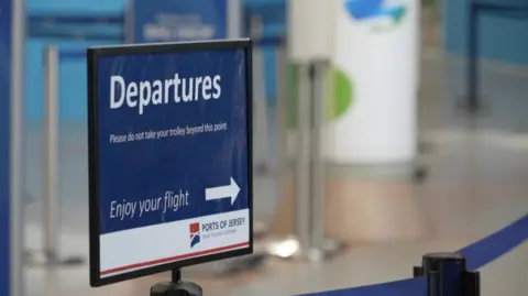 A sign which states "Departures" and an arrow which says enjoy your flight with the Ports of Jersey logo below it.