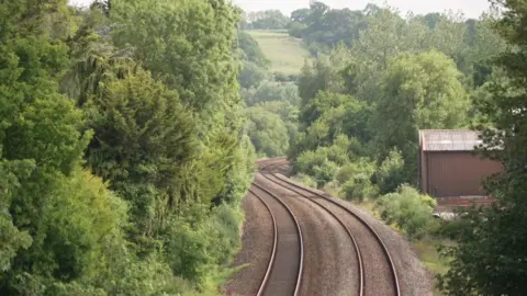 A pair of train tracks wind their way through a wooded area.