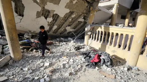 Reuters Palestinian boy walks at the site of an Israeli air strike on a school sheltering displaced people