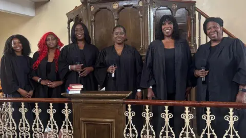 BBC A choir stands together at the pulpit, ready to deliver a performance