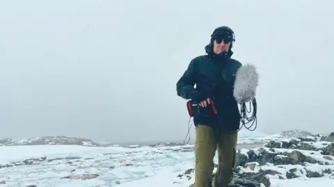 Michael Beggs Michael Begg standing in Antarctica while recording and filming 