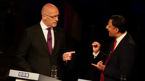 PA Media John Swinney and Anas Sarwar pointing fingers at each other during a BBC election debate