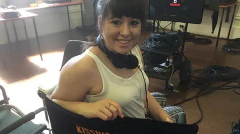 Beth Reekles A woman with dark hair wearing a white vest top