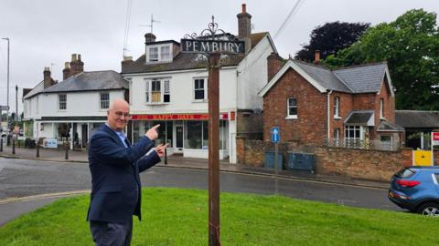 Iain Dale pointing at the Pembury sign