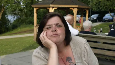 A photograph of Bridget Stewart leaning forward with her head resting against her hand
