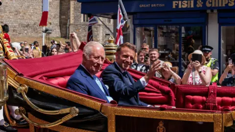 Getty Images King Charles III and President Emmanuel Macron of France proceed by carriage to Windsor Castle on the first day of the latter's state visit to the UK on 8 July 2025.