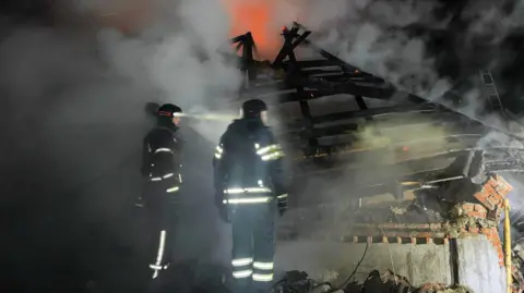 Ukraine's DSNS emergencies service/Kharkiv region Ukrainian emergencies workers inspect a destroyed house in the town of Bohodukhiv, north-eastern Kharkiv region. Photo: 11 February 2026