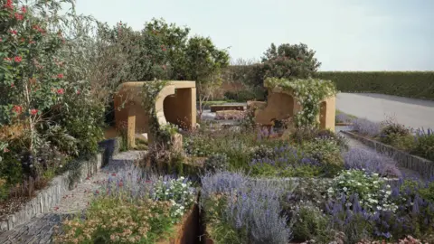 Lady Garden Foundation A carefully designed outdoor garden space. In the foreground is a arrangement of flowering plants and low shrubs featuring a mix of purples, greens, whites, and soft blues. A narrow, straight path runs along the left. There are two sculptural, curved structures made of a warm, earthy material - possibly clay, concrete, or adobe - stand slightly left and right of centre.