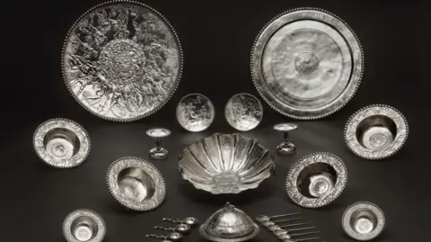 Trustees of the British Museum There are 34 pieces which include large plates and bowls, spoons, and dishes all made of silver.