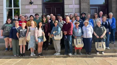Thirty members of the Poindexter Descendants Association standing on the steps of Jersey's Royal Court.