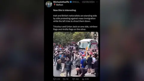 Screenshot of a tweet by Michael O'Keeffe saying: "Now this is interesting. Irish and British nationalists are standing side by side protesting against mass immigration while the left tries to shut them down. Tricolour and Union Jack on one side, rainbow flags and Antifa on the other." With a picture of the protests.