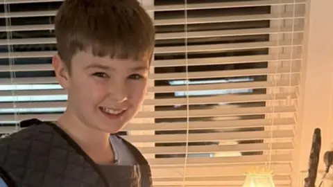 Harvey, 12, standing in the kitchen and looking into the camera smiling