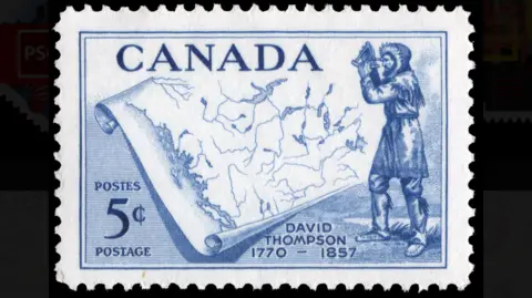 Canada Post A 1957 5 cent stamp, showing David Thompson holding a sextant, juxtaposed with a map of the Canadian territories he charted. The heading of the stamp says Canada, whilst bottom right gives his dates: 1770-1857.