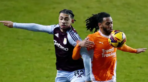 Aston Villa's Luka Lynch (left) and Blackpool's Dominic Thompson battle for the ball 