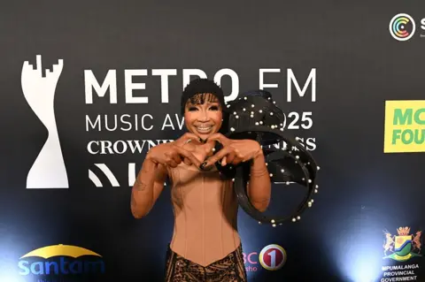 OUPA BOBAPE/GETTY IMAGES Dineo Ranaka making a heart symbol to the camera. 