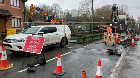 Workmen and vehicles on the closed A4069 between Lower and Upper Brynamman, Carmarthenshire