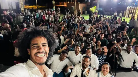 Aswat Almadina The band taking a selfie with their audience in the background. 