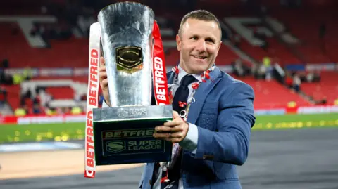 PA Media Hull KR head coach Willie Peters celebrates with the trophy following the Betfred Super League Grand Final at Old Trafford, Manchester. Picture date: Saturday October 11, 2025.